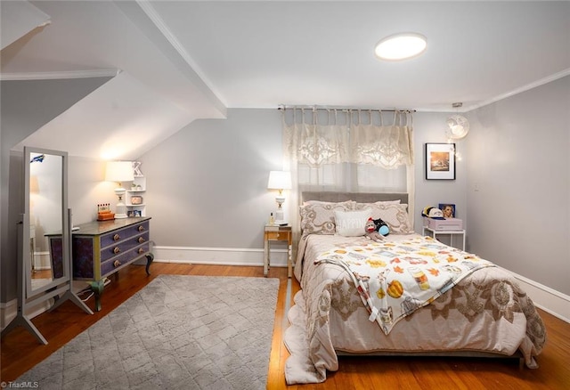 bedroom with lofted ceiling, ornamental molding, and hardwood / wood-style floors