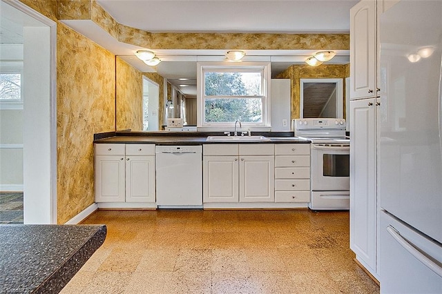 kitchen with plenty of natural light, white cabinetry, white appliances, and sink