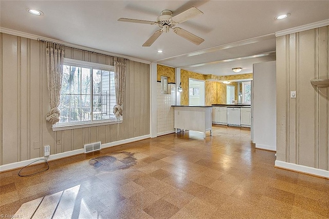 unfurnished living room featuring ceiling fan and crown molding