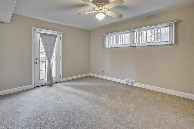 carpeted spare room featuring ceiling fan and a healthy amount of sunlight