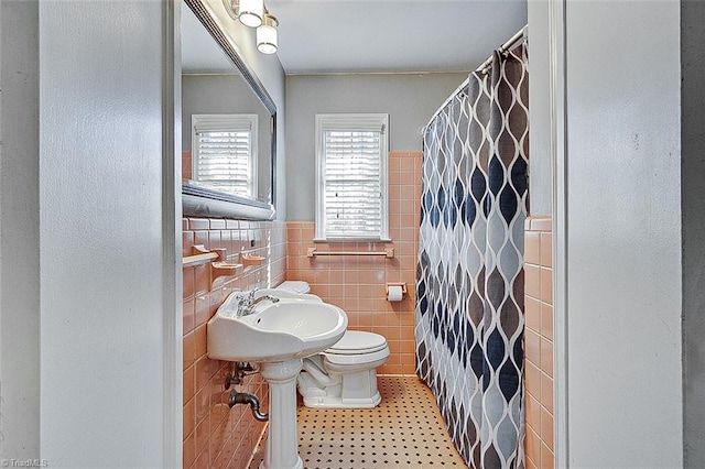 bathroom with tile patterned floors, a shower with shower curtain, tile walls, and toilet