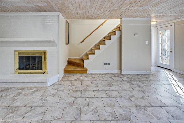 unfurnished living room with a brick fireplace and wooden ceiling