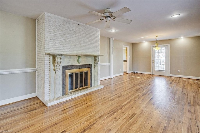 unfurnished living room featuring light hardwood / wood-style floors, a brick fireplace, and ceiling fan