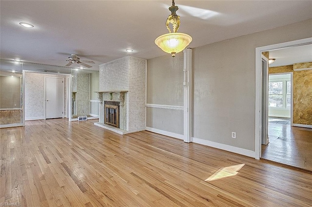 unfurnished living room with a fireplace, ceiling fan, and hardwood / wood-style floors