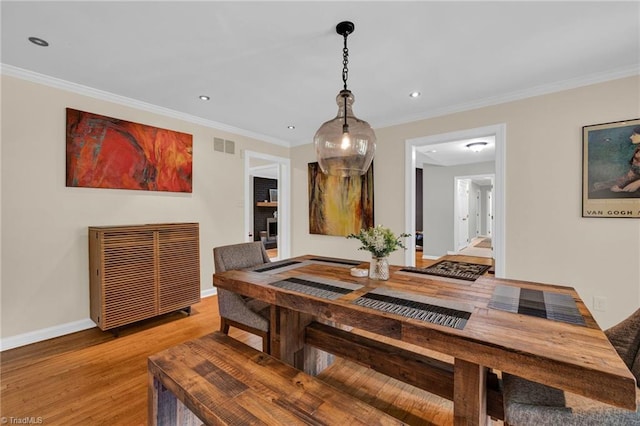 dining area featuring crown molding and light wood-type flooring