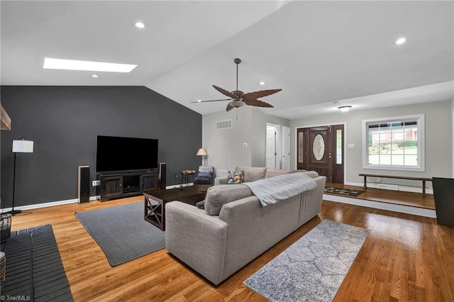 living room with ceiling fan, lofted ceiling, and light wood-type flooring