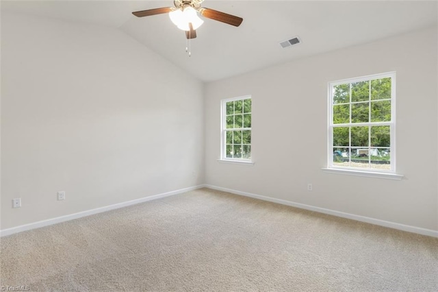 empty room with vaulted ceiling, ceiling fan, and carpet floors