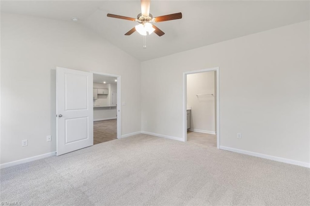 unfurnished bedroom with ceiling fan, light colored carpet, lofted ceiling, and a spacious closet