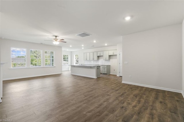 unfurnished living room with ceiling fan and dark hardwood / wood-style flooring