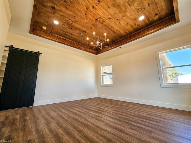 unfurnished room featuring a barn door, a notable chandelier, wood ceiling, baseboards, and a tray ceiling