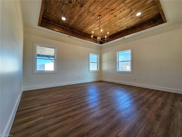 empty room with wooden ceiling, baseboards, a raised ceiling, and dark wood finished floors