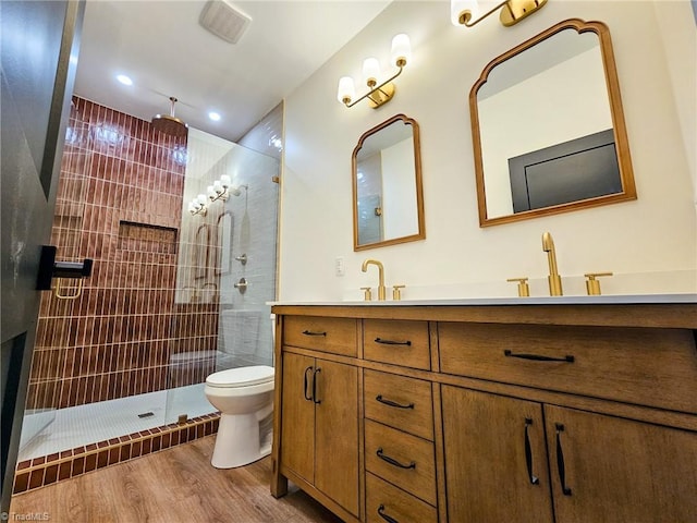 full bathroom featuring toilet, a walk in shower, a sink, and wood finished floors