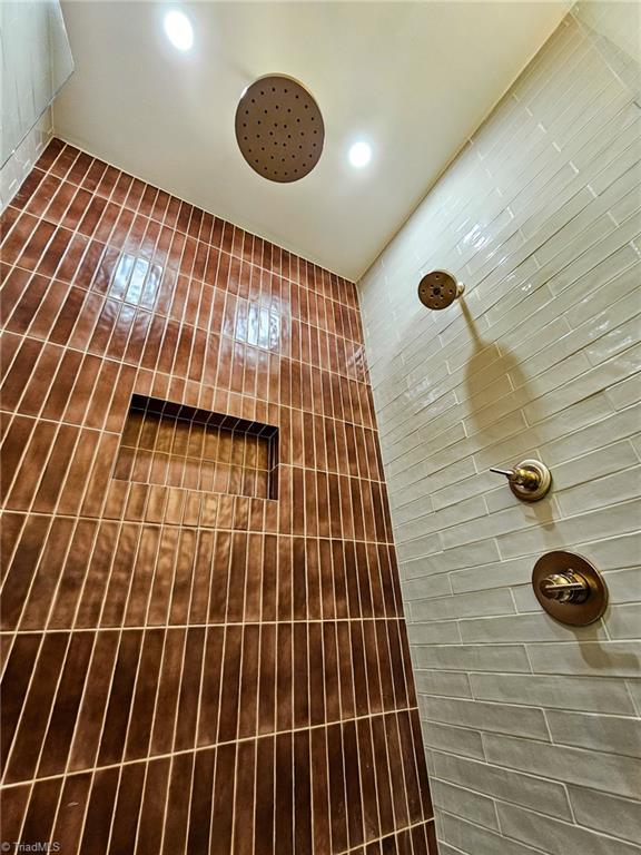 full bathroom featuring tiled shower and recessed lighting