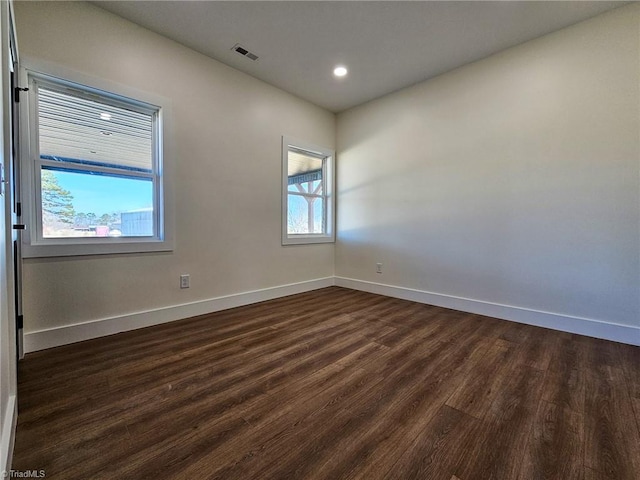 spare room with dark wood-style floors, recessed lighting, visible vents, and baseboards