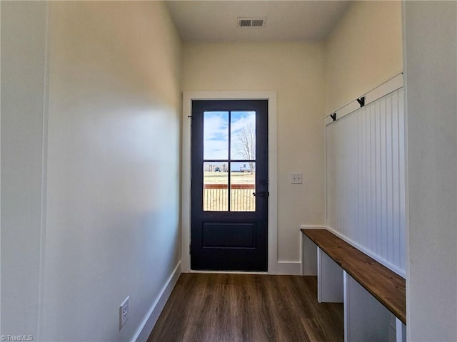 doorway to outside featuring baseboards, visible vents, and dark wood finished floors