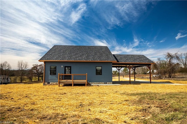 back of house with a lawn, roof with shingles, crawl space, a wooden deck, and a carport