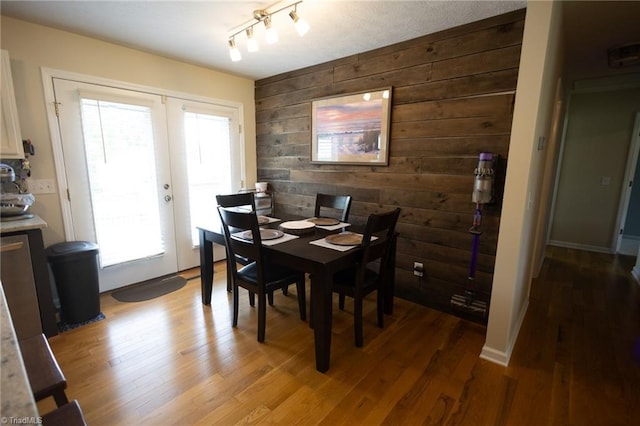 113 Stone Bridge Rd, Mount Airy, NC 27030 - dining room with wooden walls, light wood-style floors, french doors, and an accent wall