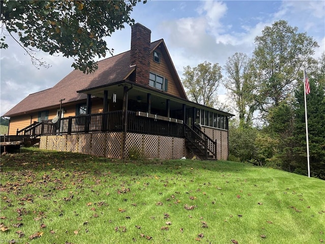 view of side of home featuring a lawn and a deck