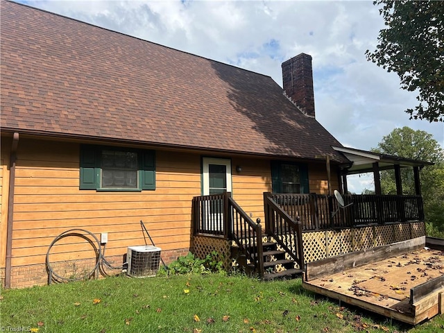 back of house with a deck, a lawn, and central air condition unit