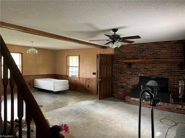 interior space with a textured ceiling, beam ceiling, and wood walls