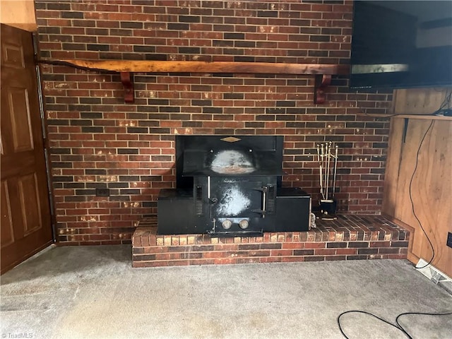 interior details featuring carpet, a fireplace, and a wood stove