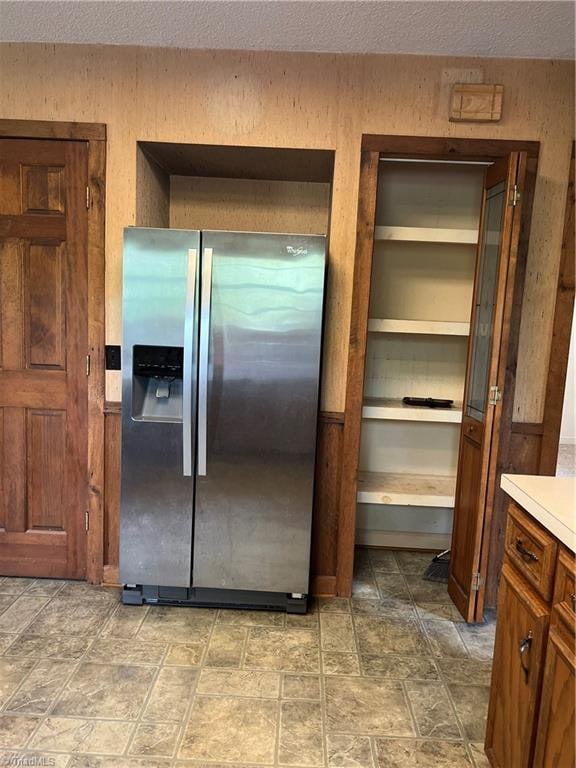 kitchen featuring stainless steel refrigerator with ice dispenser and a textured ceiling