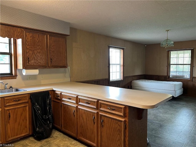 kitchen featuring pendant lighting, a kitchen breakfast bar, kitchen peninsula, and a healthy amount of sunlight