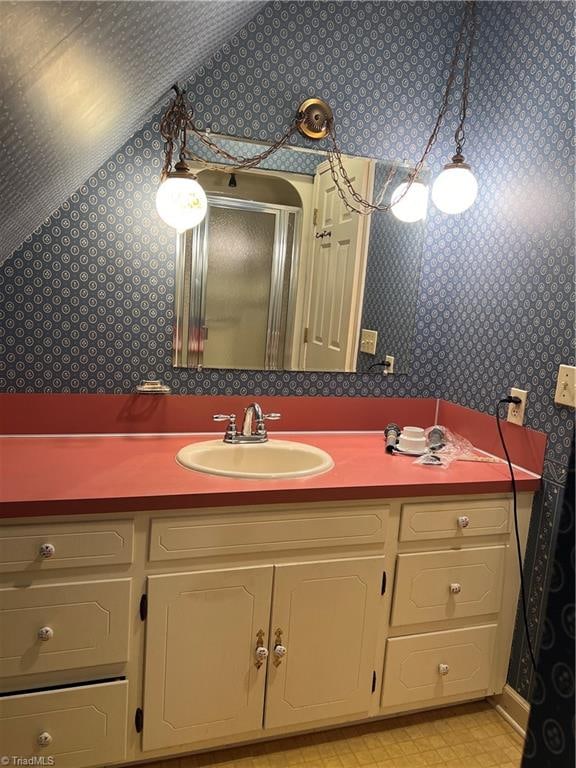 bathroom with lofted ceiling, vanity, and an enclosed shower