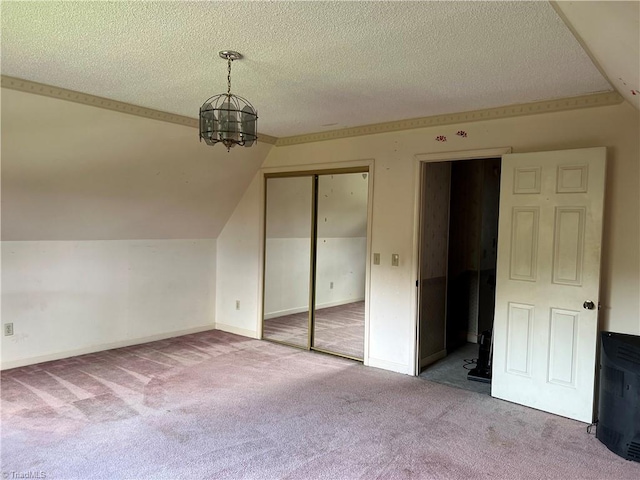 unfurnished bedroom featuring light carpet, lofted ceiling, a closet, and a chandelier