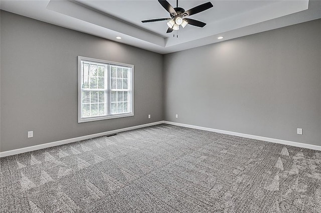 carpeted spare room with a tray ceiling, baseboards, a ceiling fan, and recessed lighting