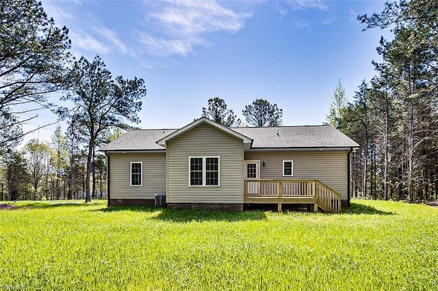back of property with a yard, a deck, and roof with shingles