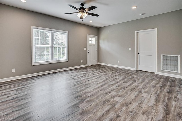 unfurnished living room featuring visible vents, baseboards, a ceiling fan, and wood finished floors