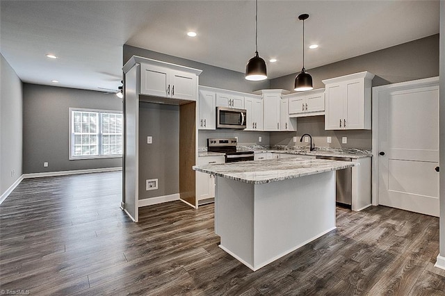 kitchen with a center island, a sink, a ceiling fan, dark wood-style floors, and stainless steel appliances