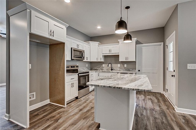 kitchen featuring dark wood-style floors, baseboards, a sink, and appliances with stainless steel finishes