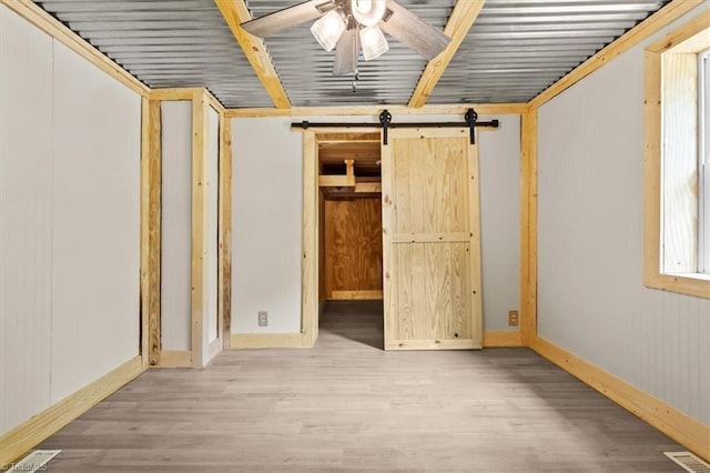 539 W Salisbury St, Denton, NC 27239 - unfurnished bedroom with wood finished floors and a barn door