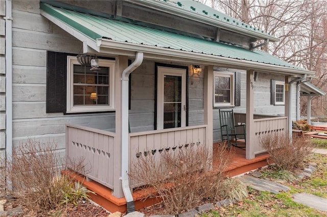 entrance to property featuring covered porch and metal roof