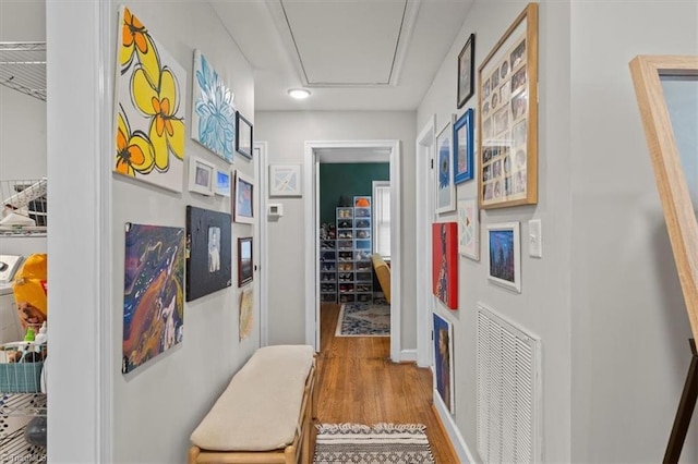 corridor with visible vents, baseboards, and wood finished floors