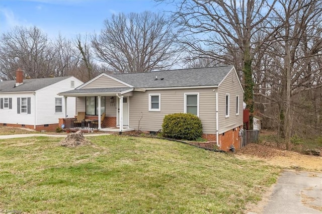 view of front facade with a front lawn, covered porch, roof with shingles, and crawl space