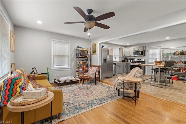 living area with recessed lighting, light wood-type flooring, and ceiling fan