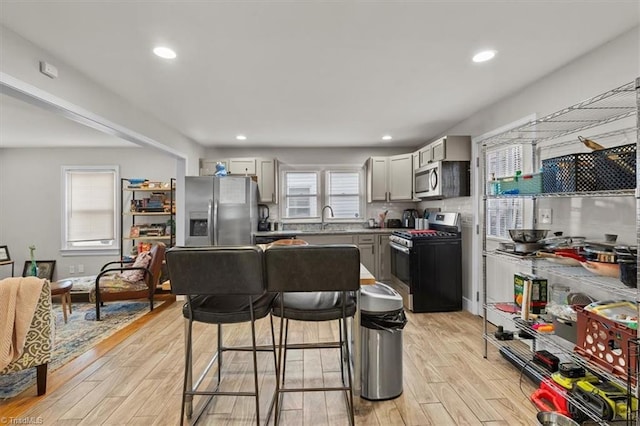 kitchen featuring a sink, stainless steel appliances, light wood-style flooring, and recessed lighting