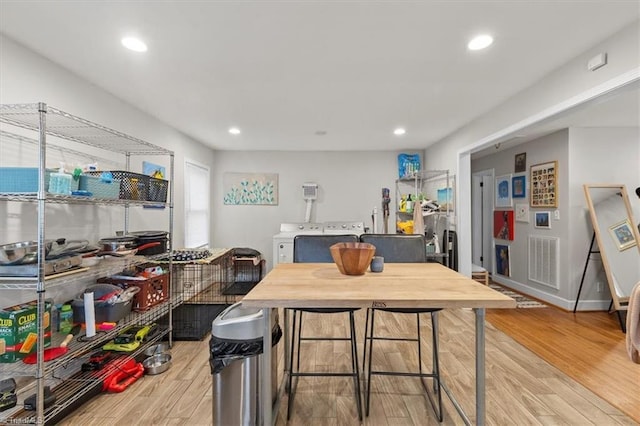 dining space featuring washing machine and dryer, recessed lighting, baseboards, and light wood-style floors