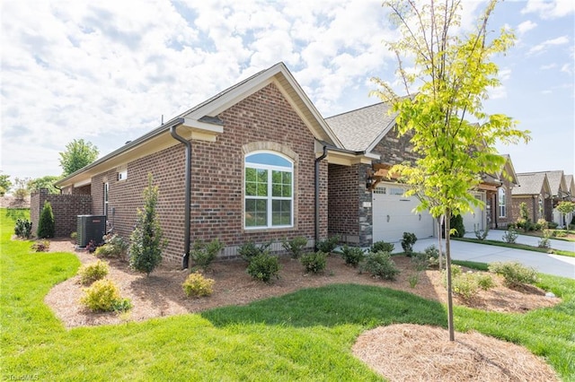 view of front of house featuring a front yard, central AC unit, and a garage