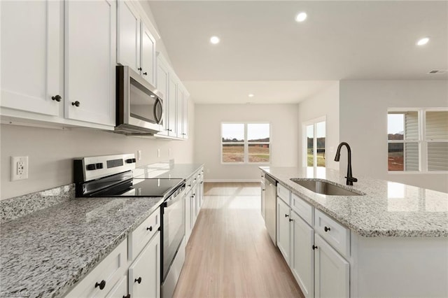 kitchen with a center island with sink, sink, white cabinetry, and stainless steel appliances