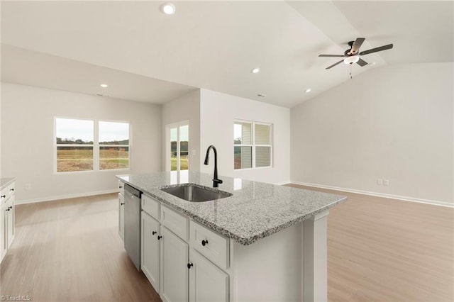 kitchen with dishwasher, lofted ceiling, a center island with sink, sink, and light hardwood / wood-style floors