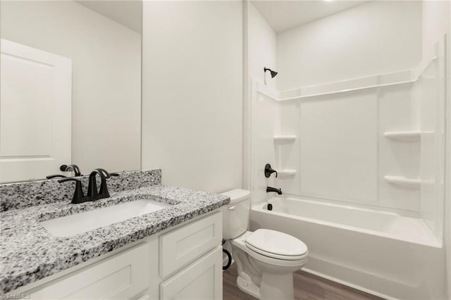 full bathroom with washtub / shower combination, wood-type flooring, vanity, and toilet