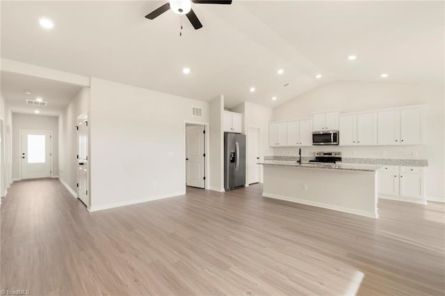 unfurnished living room featuring ceiling fan, vaulted ceiling, and light wood-type flooring