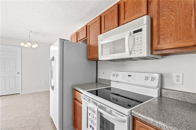 189 Lochshire Ln, Woodleaf, NC 27054 - kitchen featuring white appliances, brown cabinets, a chandelier, light floors, and a textured ceiling