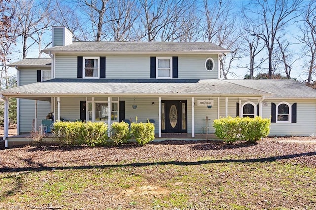 farmhouse featuring covered porch and a chimney