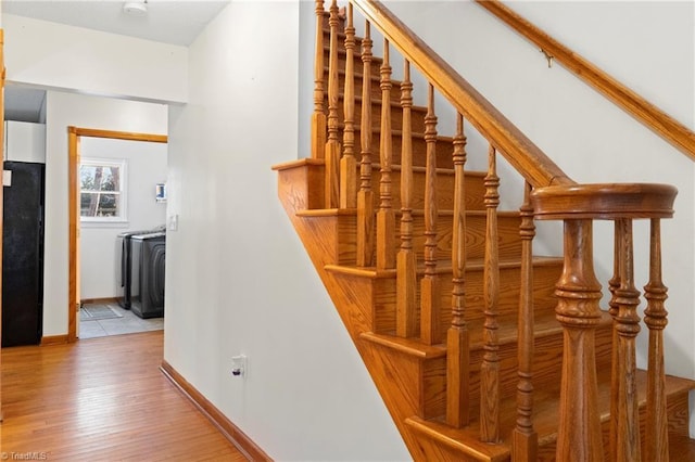 staircase with baseboards and wood finished floors