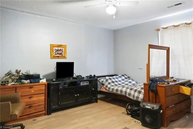 bedroom with light wood-type flooring, visible vents, and ceiling fan